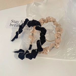 Détail de serre-têtes en satin plissé avec chaînes de strass étincelantes en noir et beige