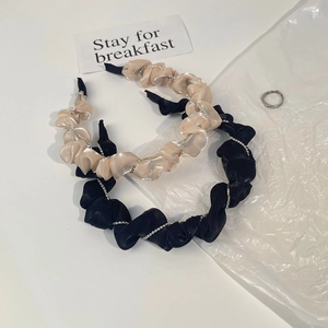 Gros plan de serre-têtes en satin plissé avec chaînes de strass en doré et noir
