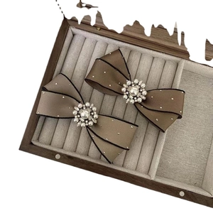 French style pearl and rhinestone bow hair clip in taupe satin with gold stud accents