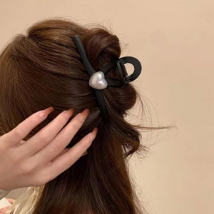 Matte black hair claw clip with silver heart pearls shown on long brown hair