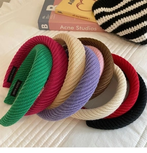 Detailansicht bunter Strickstirnbänder mit handgefertigten Etiketten und weicher Webstruktur