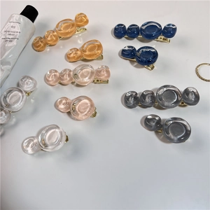 Vue détaillée des barrettes en résine à bulles colorées sur montures dorées
