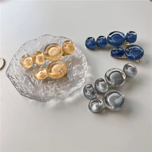 Détail de barrettes en résine à texture bulle en ambre, bleu et gris sur base dorée