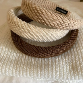 Nahaufnahme gestrickter breiter Haarbänder in Erdtönen mit handgefertigten Stoffetiketten