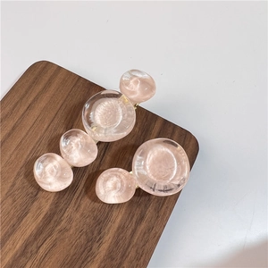 Détail de pinces à cheveux en résine rose effet bulles sur support bois foncé