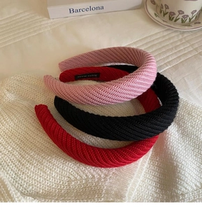 Detail der Strickstruktur von drei bunten Puffy-Stirnbändern mit handgefertigten Etiketten