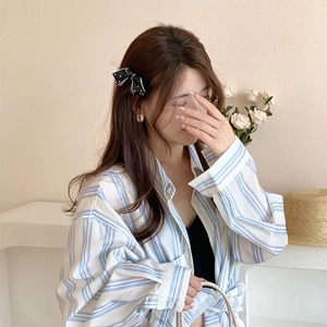 Detailed close-up of a blue and white striped cotton-blend long sleeve button-up shirt