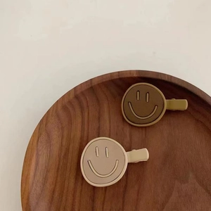 Pair of minimalist smile face hair clips in olive green and beige matte finish
