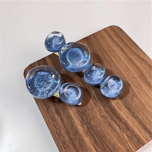 Paire de barrettes à bulles bleues avec base en métal doré sur présentoir en bois