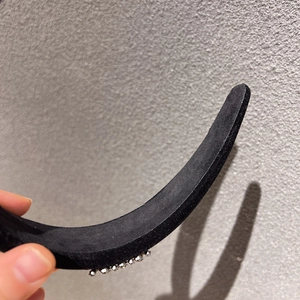 Close-up detail of luxury wide black velvet headband with sparkling rhinestone trim