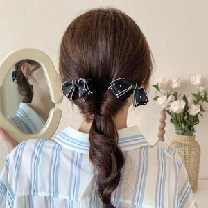 Elegant pair of black bow hair clips with white polka dots for side hair styling