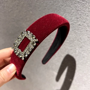 Detail of burgundy velvet headband featuring luxury rectangular rhinestone buckle accents