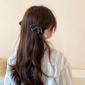 French style black and white polka dot bow hair clip on long wavy brown hair