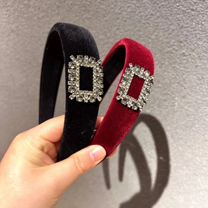 Close-up of velvet wide headbands in black and burgundy with crystal buckle detail