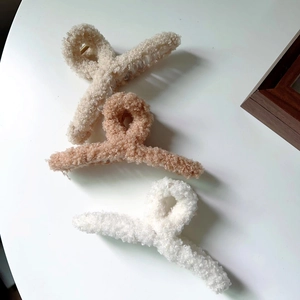 Trois pinces à cheveux en peluche de couleurs crème, marron clair et blanc pour l'hiver