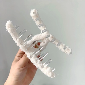 Vue détaillée de la texture en fausse fourrure blanche sur une grande pince à cheveux d'hiver