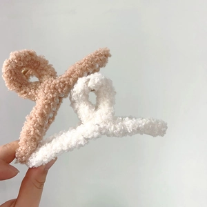 Gros plan de grandes pinces à cheveux en peluche crème et kaki avec texture polaire douce