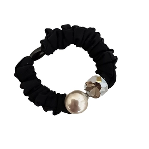 Elegante elastico per capelli nero con perla champagne e cristallo su sfondo bianco