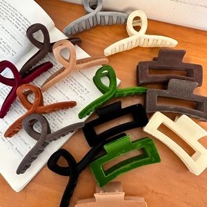 Close-up of velvet hair claws in various vintage colors on a wooden background