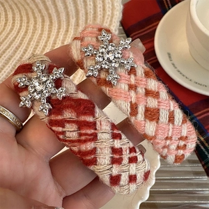 Close-up of red and pink plaid tweed hair clips with crystal silver snowflake charms