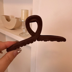 Detailed view of deep brown matte hair claw clip with twisted design and strong teeth grip