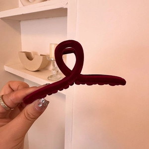 Detail of burgundy velvet hair claw clip showing soft texture and non-slip teeth grip