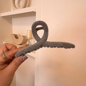 Detail of dark grey velvet hair claw clip with a matte finish and spiral structure
