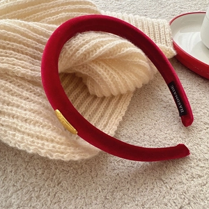 Elegant red velvet headband with vintage gold buckle on a premium knitted background