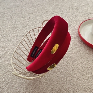 Detailed view of handmade vintage red velvet headband with gold-tone oval accent and label