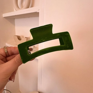 Detail of dark green velvet hair claw clip with rectangular geometric hollow design