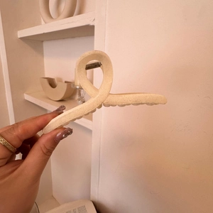 Close-up of minimalist cream white velvet hair claw clip with matte finish texture