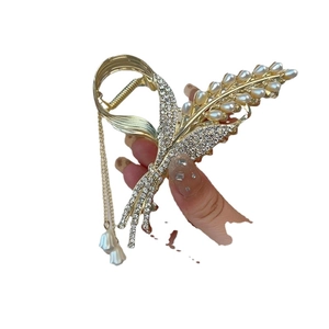 Elegant gold flower shark hair clip with white pearls and sparkling rhinestone tassels