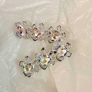 Dettaglio di fermagli in lega d'argento con cristalli a cuore rosa e aurora e piccoli strass