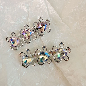 Dettaglio di fermagli per capelli a fiore d'argento con cristalli iridescenti a cuore