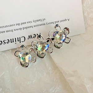 Dettaglio macro di tre fermagli per capelli a cuore in cristallo con strass colorati su base