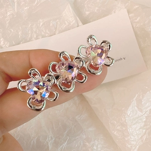 Dettaglio di tre cristalli a cuore rosa su un fermaglio per capelli floreale argento