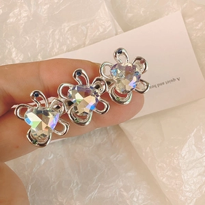 Dettaglio fermaglio per capelli a fiore argento con tre cristalli a cuore e gemme colorate