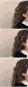 Details von roten und schwarzen Samt-Haarspangen mit Perlen auf braunem Haar