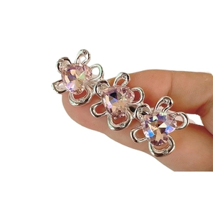 Fermaglio per capelli a fiori argentati con cuori di cristallo rosa in primo piano