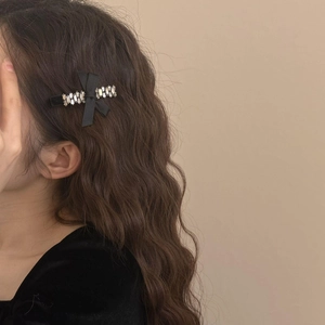 Klassische schwarze Samt-Schleifenspange mit Glitzersteinen im gewellten Haar
