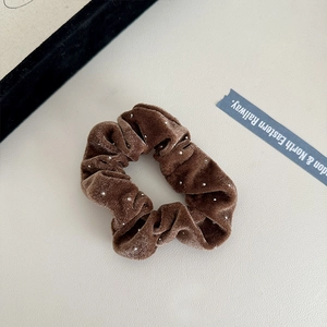 Detailed texture of brown velvet hair scrunchie with sparkling silver beads and soft folds