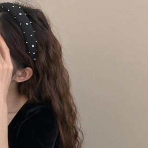 Cerchietto imbottito nero con strass argentati brillanti su elegante superficie in raso