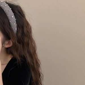 Elegante cerchietto grigio con strass e perline d'argento su una modella mora