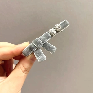 Dettaglio del fermaglio a fiocco in velluto grigio con strass luccicanti ed eleganti