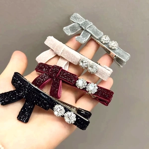 Dettaglio di fermagli a fiocco in velluto in quattro colori con strass lucidi
