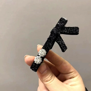 Fermaglio per capelli incrociato nero in tessuto lucido con due strass scintillanti