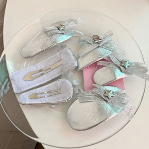 Détail de barrettes à cheveux en tissu argenté avec nœuds et étoiles sur plateau