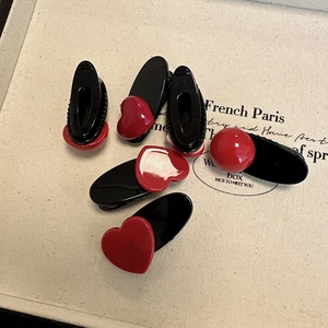 Détail de pinces à cheveux cœur rouge avec texte France Handmade sur tissu beige