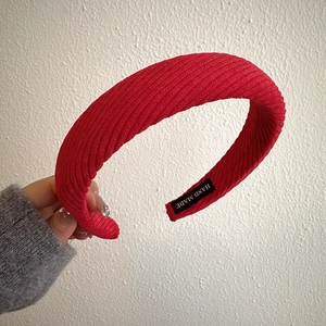Detail of red corduroy padded headband with a hand made woven label on the inner side