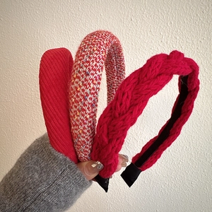 Detailed close-up of three red festive headbands featuring knitted and woven textures